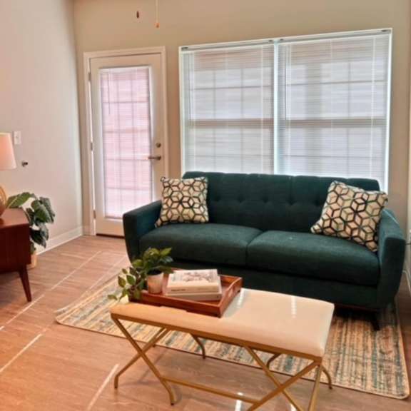 a living room with a green couch and a ceiling fan.