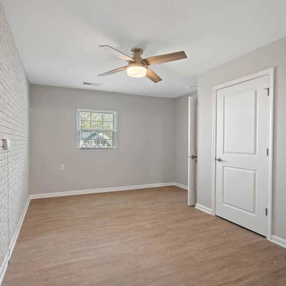 a room with a ceiling fan and a window.