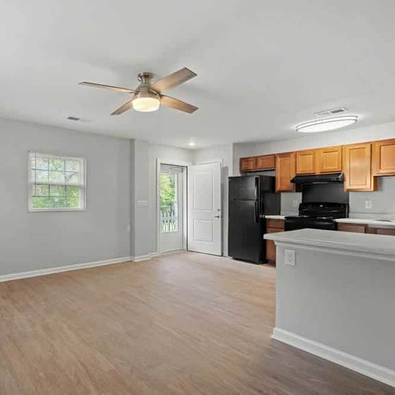 a kitchen with a black refrigerator and wooden cabinets.