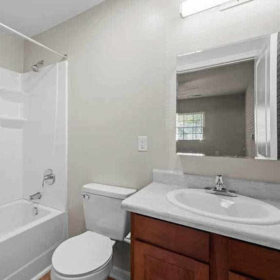 a white bathroom with a toilet, sink, and bathtub.
