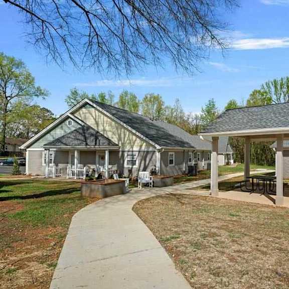 a house with a covered patio and a walkway leading to it.
