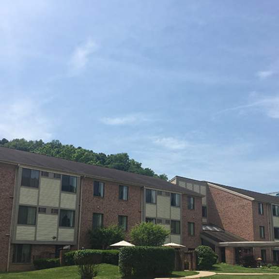 a large brick building with a parking lot in front.
