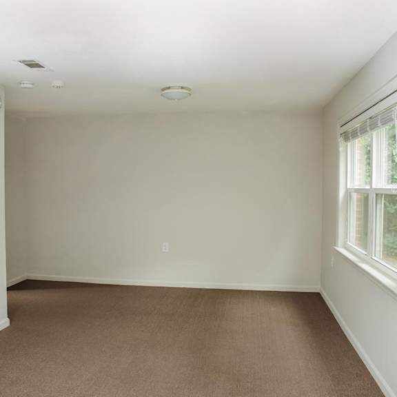 a room with a window and carpeted floor.
