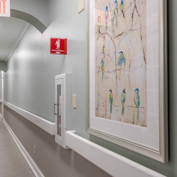 a long hallway with a red exit sign at the top.
