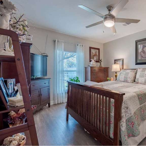 a bedroom with a bed, dresser, and ceiling fan.