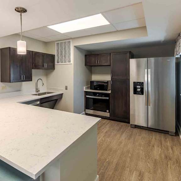 a kitchen with a white countertop and stainless steel appliances.