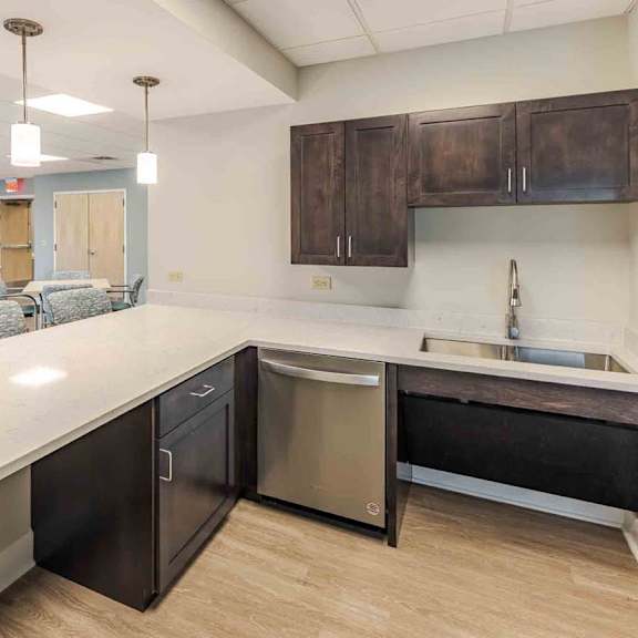 a kitchen with a white countertop and dark brown cabinets.