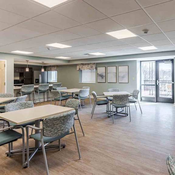 a room with tables and chairs and a clock on the wall.