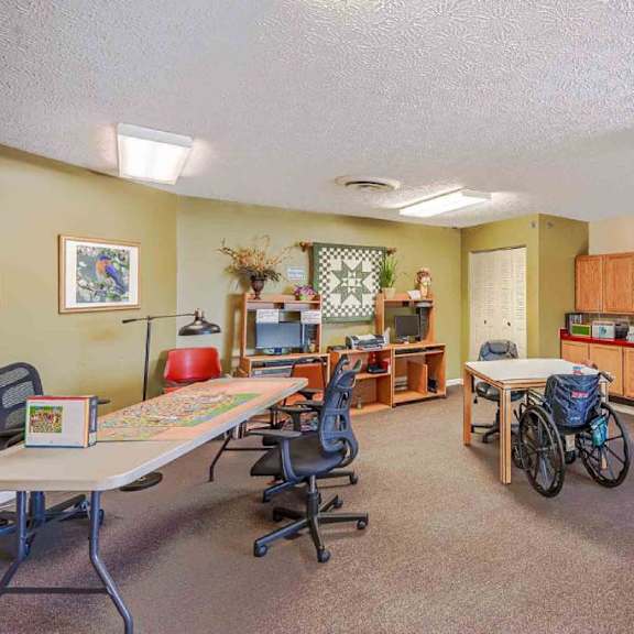 a room with a table, chairs, and a bicycle.