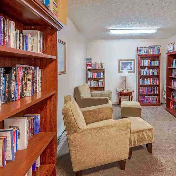 a room filled with bookshelves and a couple of chairs.