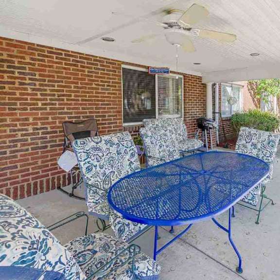 a patio with a blue table and chairs.