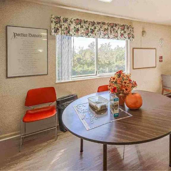 a living room with a table, chairs, and a television.