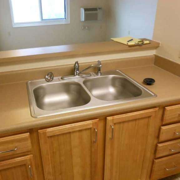 a kitchen with a sink and wooden cabinets.
