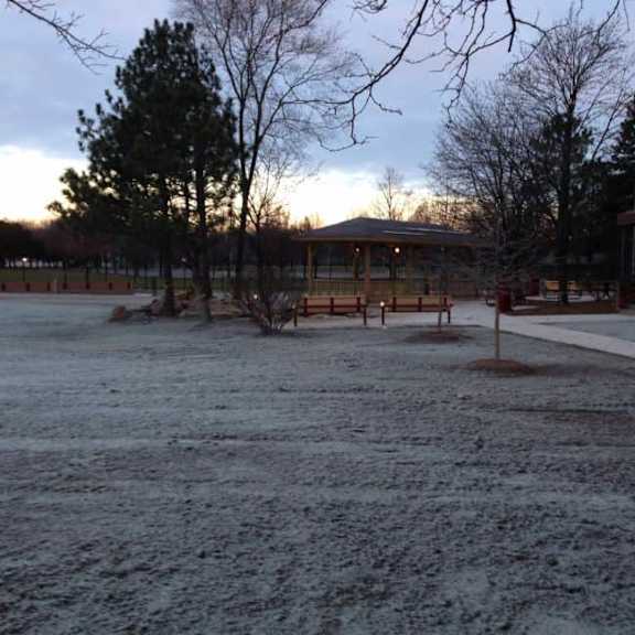 a snow-covered ground with a gazebo in the background.