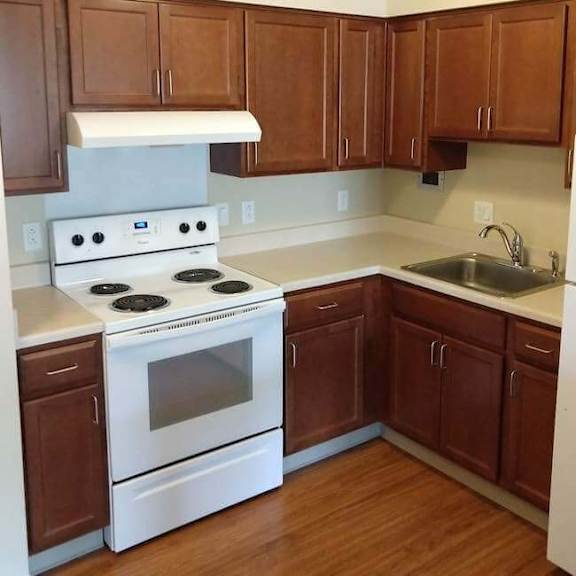 a kitchen with white appliances and brown cabinets.