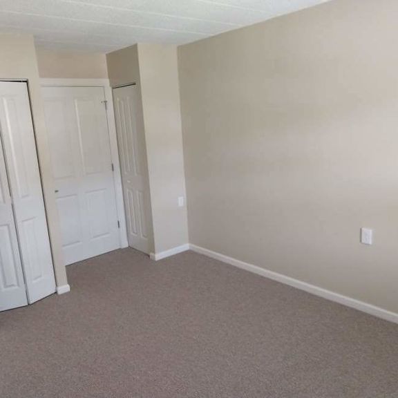 a room with white doors and carpeted floor.