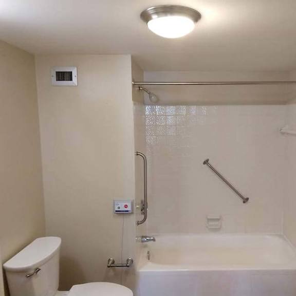 a white bathroom with a toilet, sink, and bathtub.