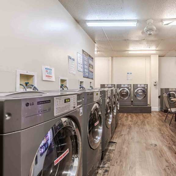 a row of lg front load washing machines are lined up in a laundromat.