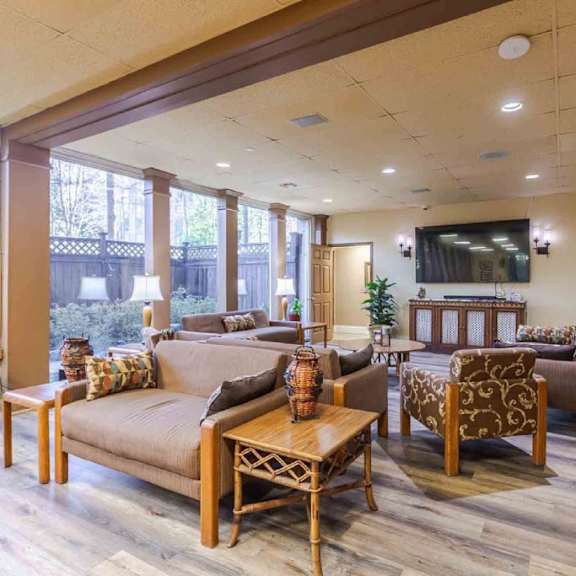 a living room with a brown couch and wooden furniture.