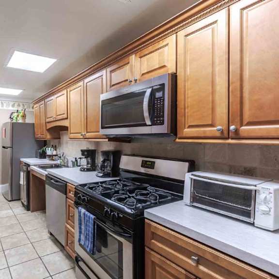 a kitchen with wooden cabinets and a white countertop.