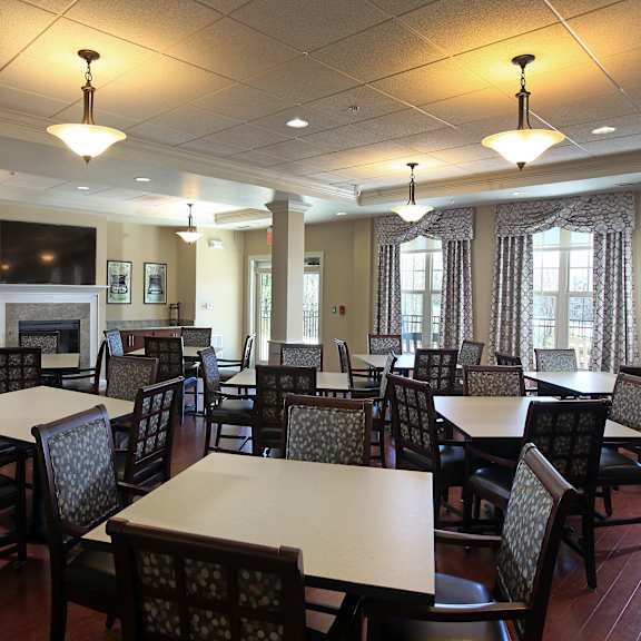 a large room with tables and chairs and a fireplace.
