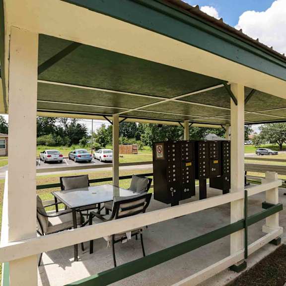 a covered picnic area with a table and chairs.