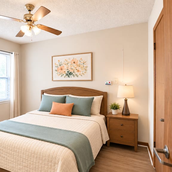 a bedroom with a bed, nightstand, and a ceiling fan.
