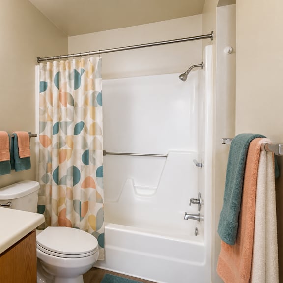 a bathroom with a white toilet, a white sink, and a shower curtain.