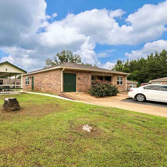 a house with a green roof and a covered patio area.