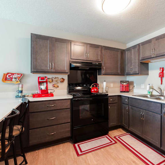 a black refrigerator with a magnet on it in a kitchen.