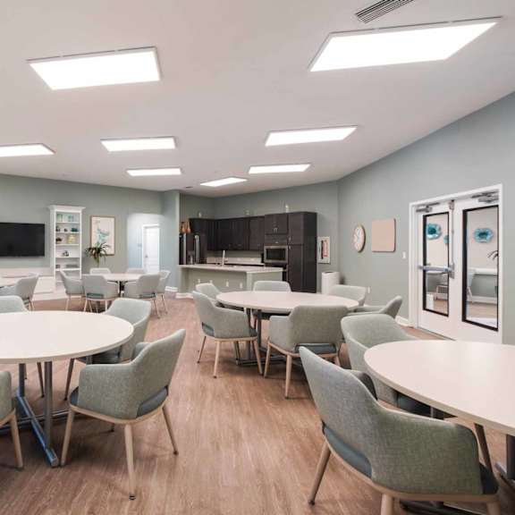 a room with tables and chairs and a whiteboard.