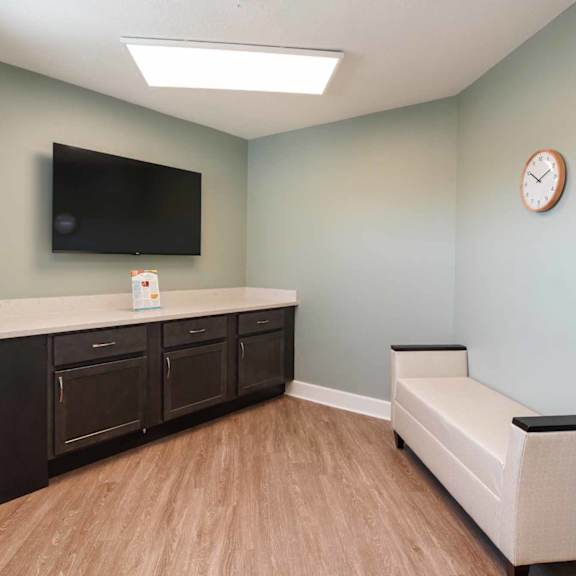 a living room with a flat screen tv mounted on the wall and a bench.