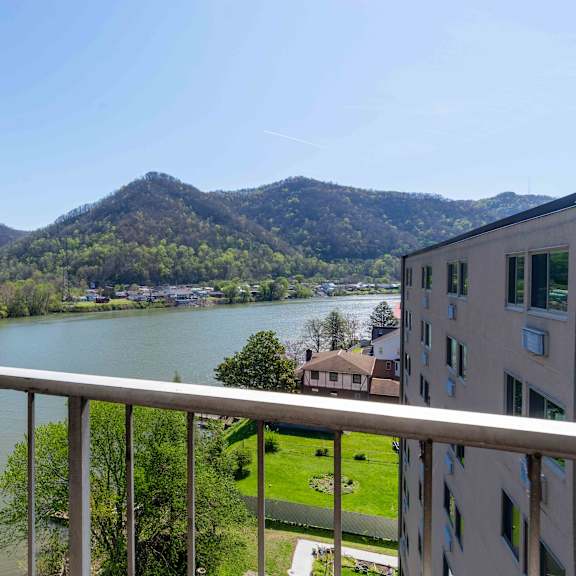 a balcony overlooks a river and a mountain.
