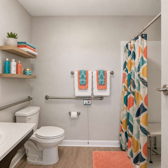 a bathroom with a white toilet, sink, and shower curtain.