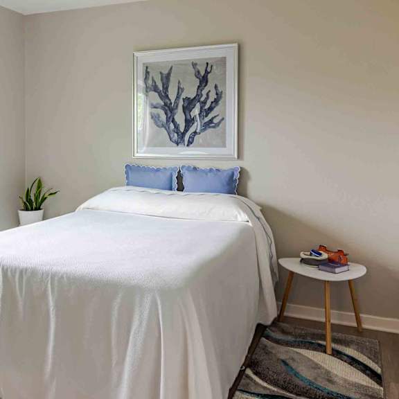 a bedroom with a white bed and a blue pillow.