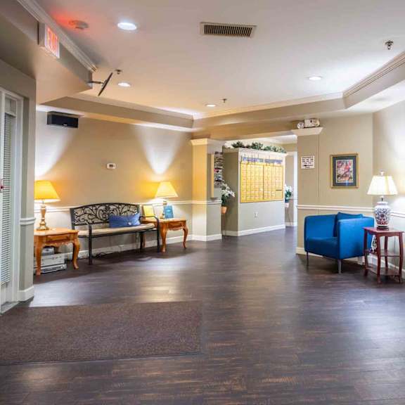 a waiting room with a blue chair and a couch.