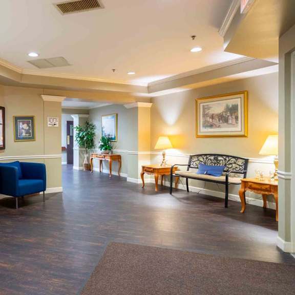 a spacious living room with a blue sofa and wooden floors.