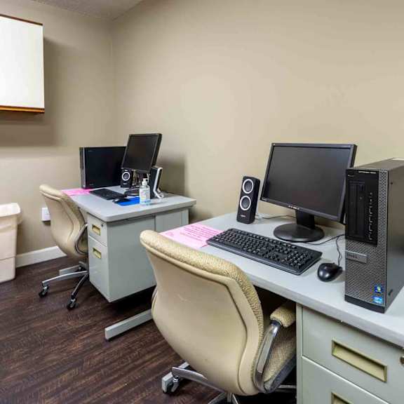two computers on desks in a room.
