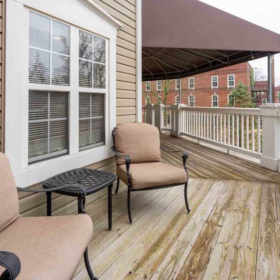 a wooden deck with two chairs and a table.