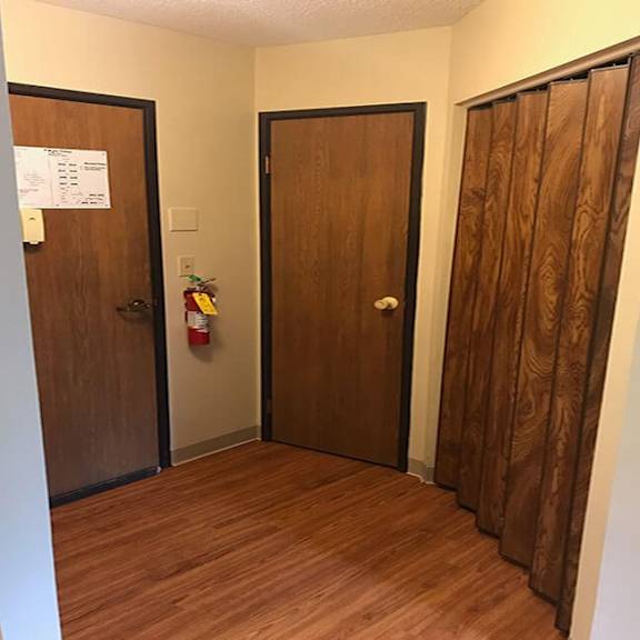 a hallway with two doors and a sign on the wall.