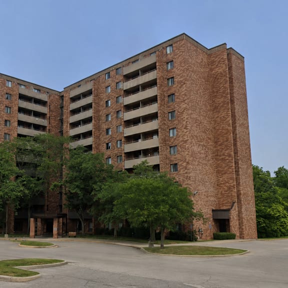 a large brown building with a parking lot in front.