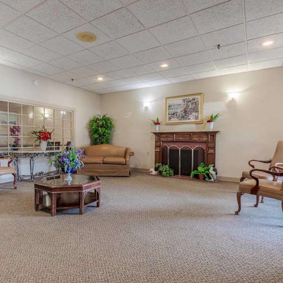 a living room with a fireplace and a painting on the wall.