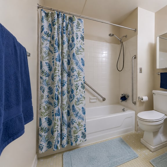 a blue and white shower curtain hangs over a white bathtub in a bathroom.