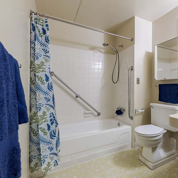 a bathroom with a toilet, sink, and shower.