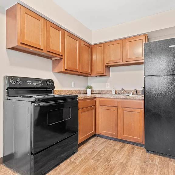 a kitchen with black appliances and wooden cabinets