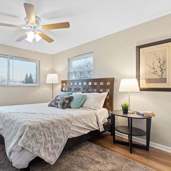 a bedroom with a bed and a ceiling fan