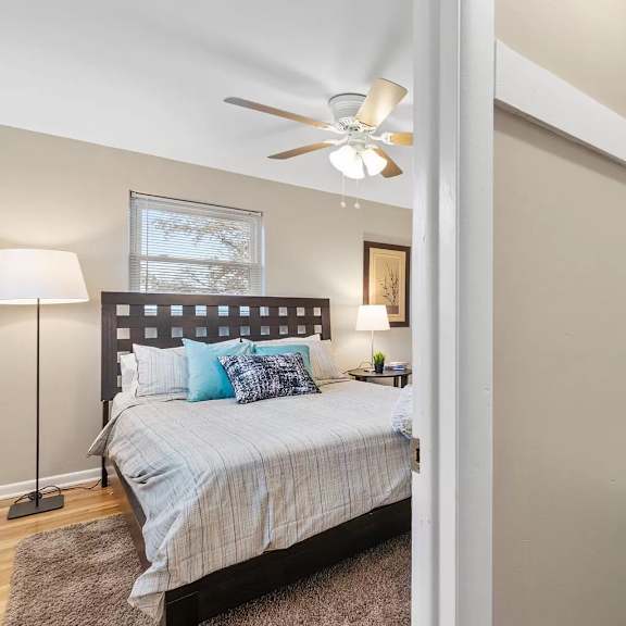 a bedroom with a bed and a ceiling fan