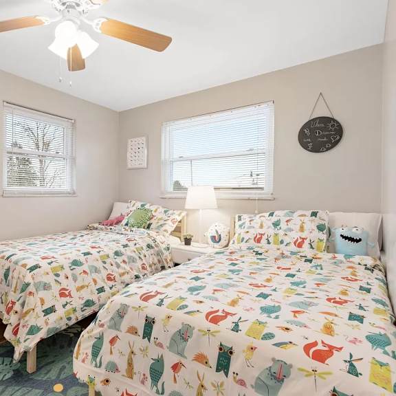 a bedroom with two beds and a ceiling fan