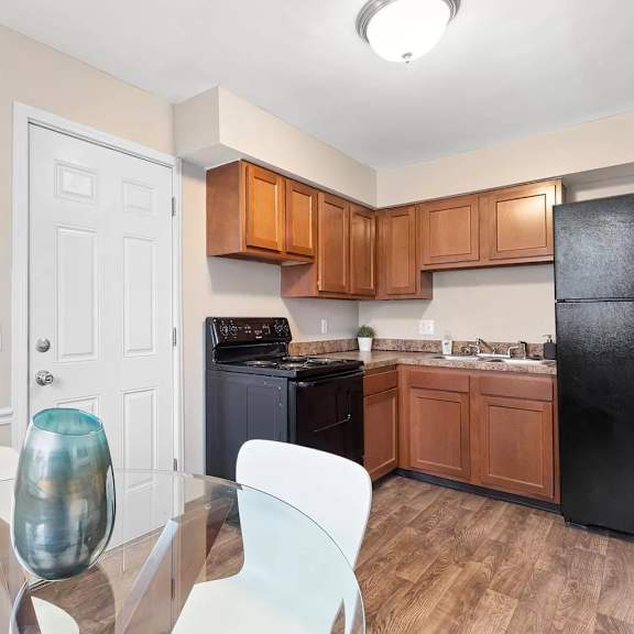 a kitchen with a table and a black refrigerator