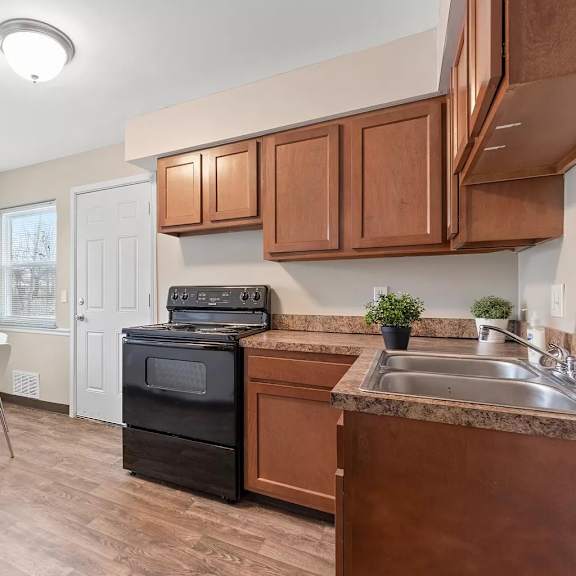 a kitchen with wooden cabinets and a table with chairs